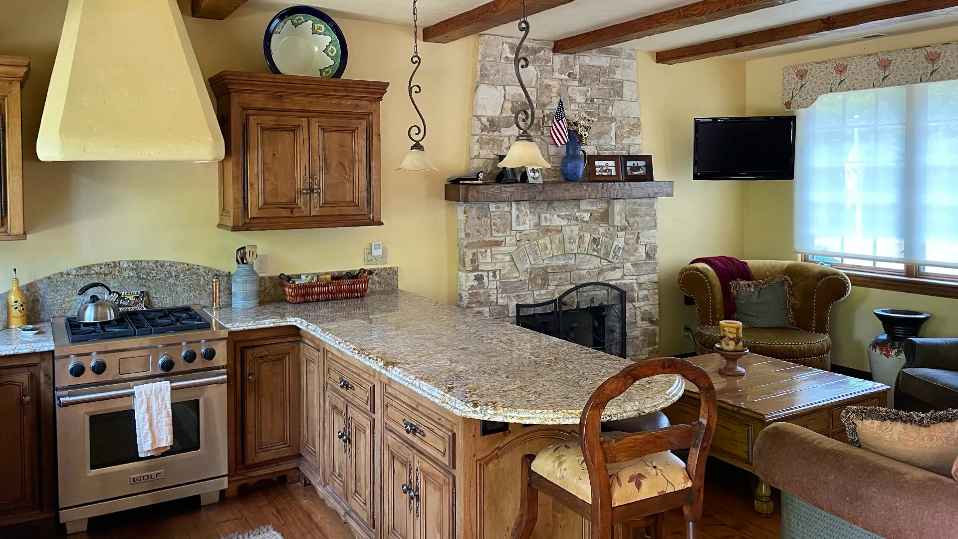 Kitchen with Wolf range, granite counters and stone fireplace