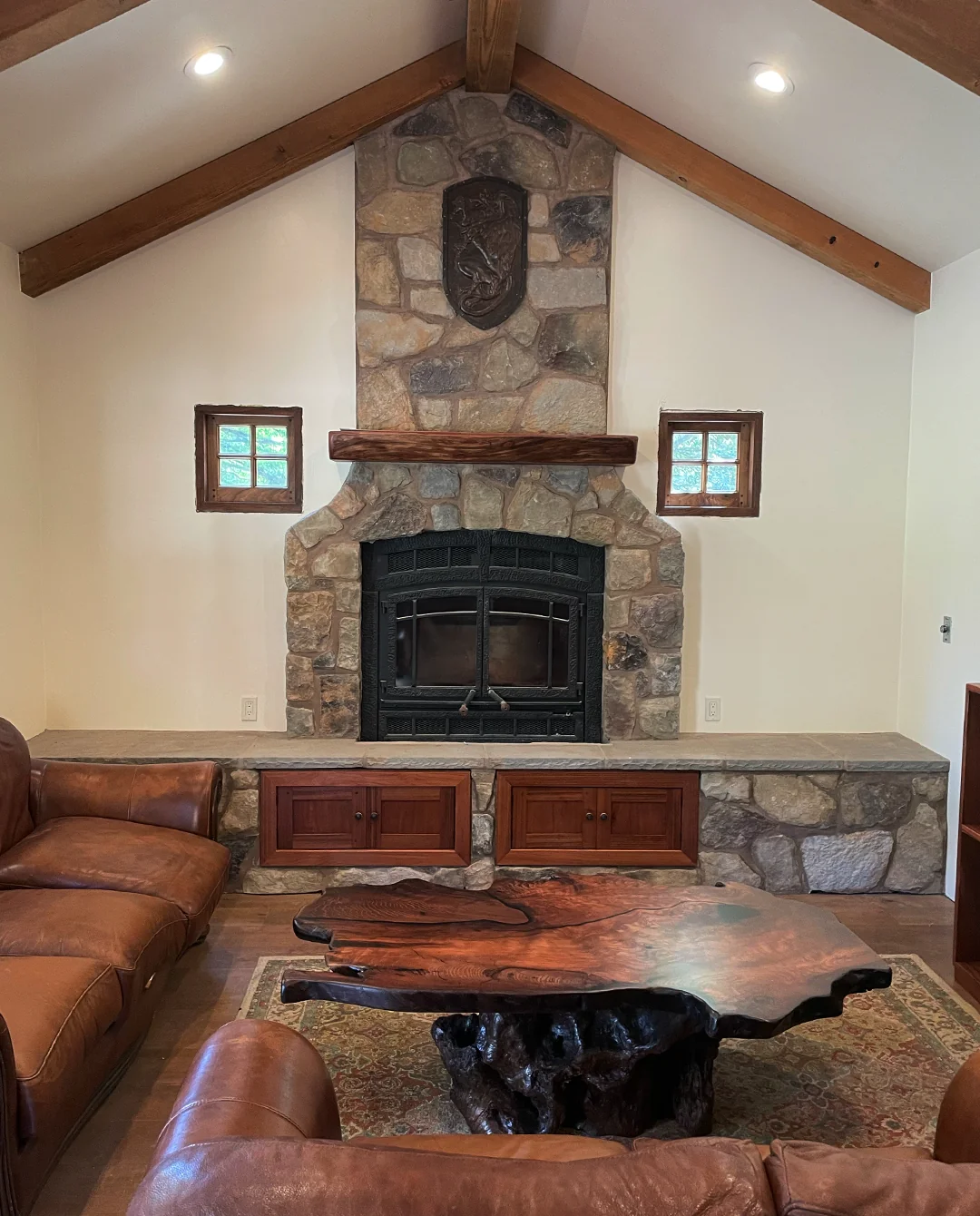 Vaulted living room with stone fireplace and live-edge table