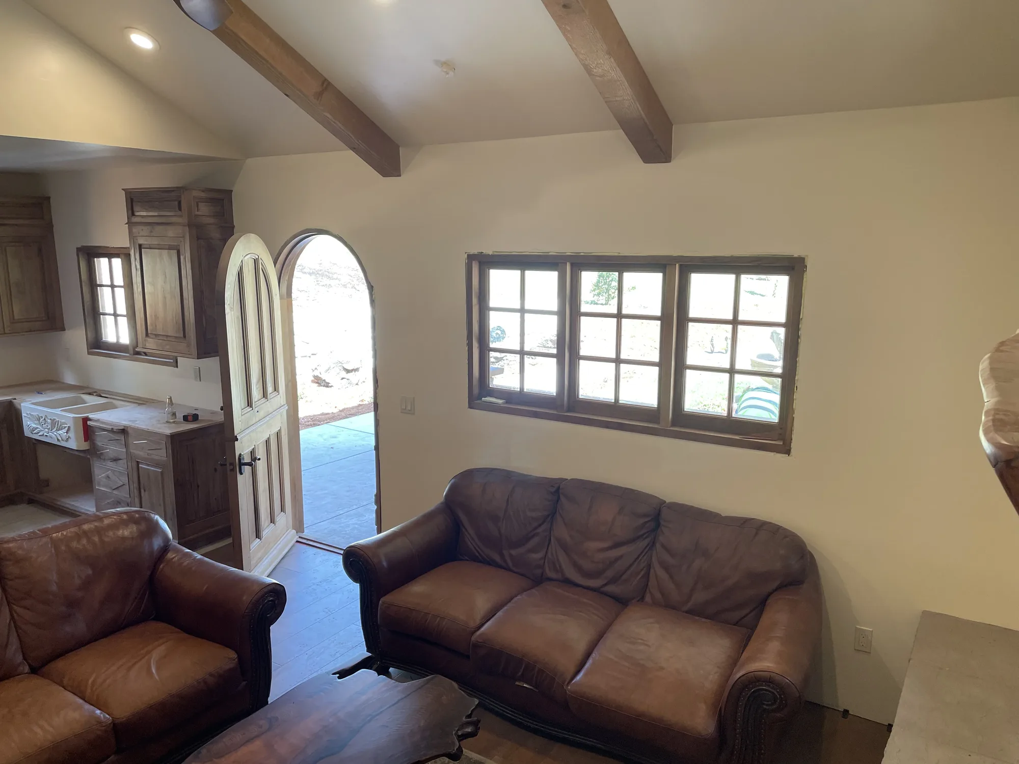 Living room with arched front door and leather sofas
