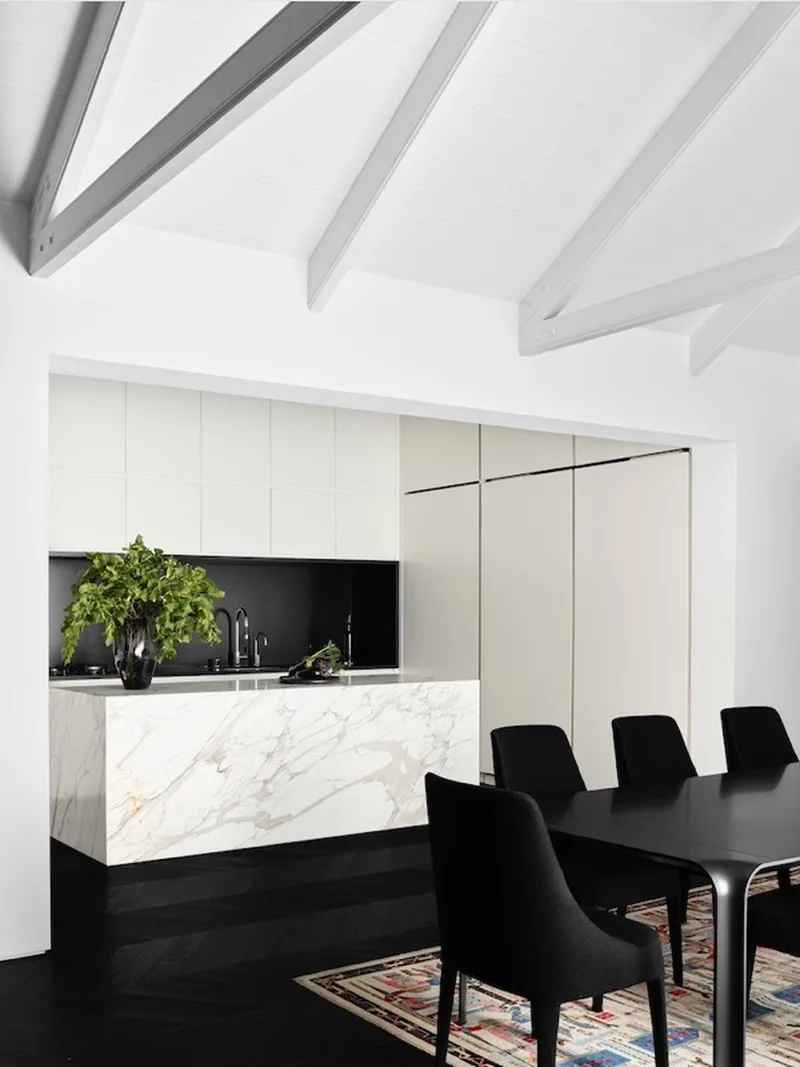Kitchen with marble island under vaulted beams